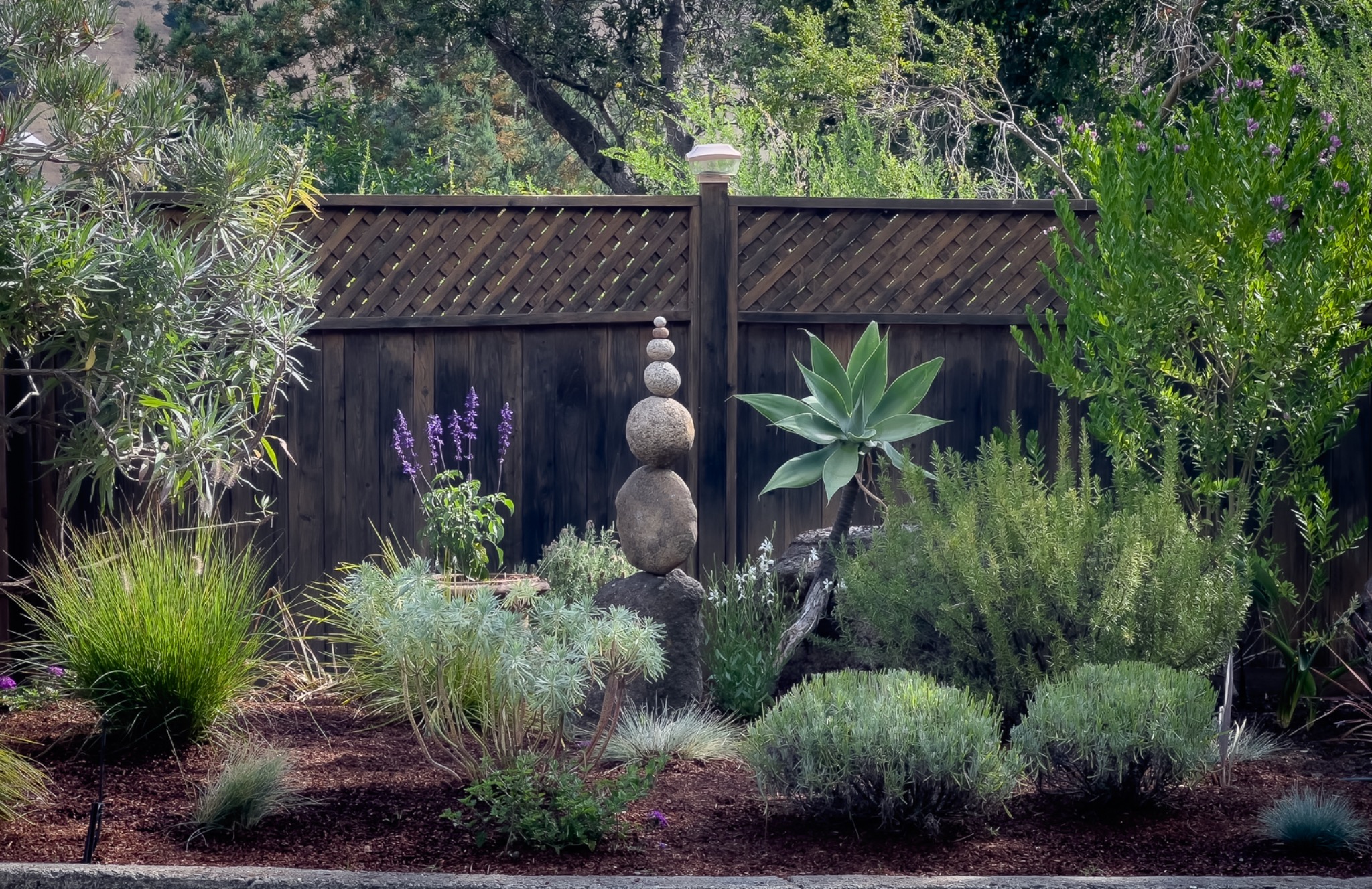 Balanced stones standing in a garden among green plants
